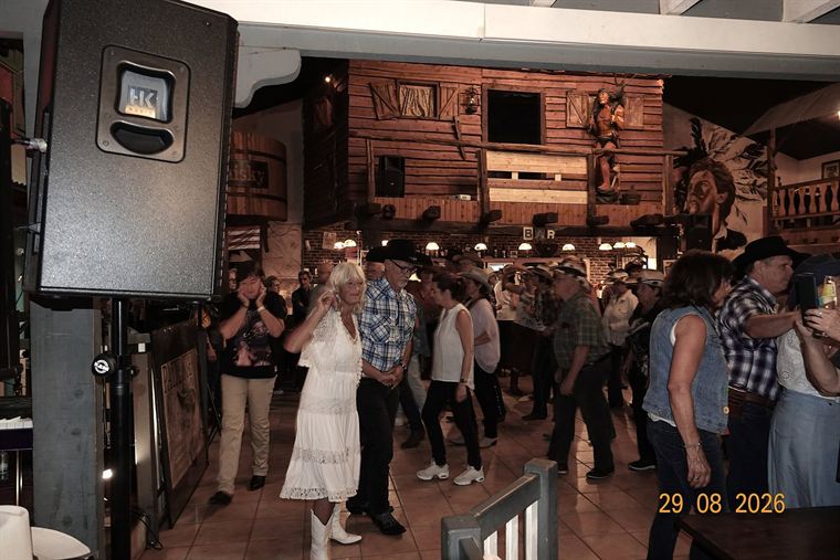 Volle zaal van The Papillon Saloon met dansers voor het podium